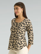 Woman wearing a patterned top with a plain background