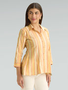 Woman wearing a striped shirt against a gray background