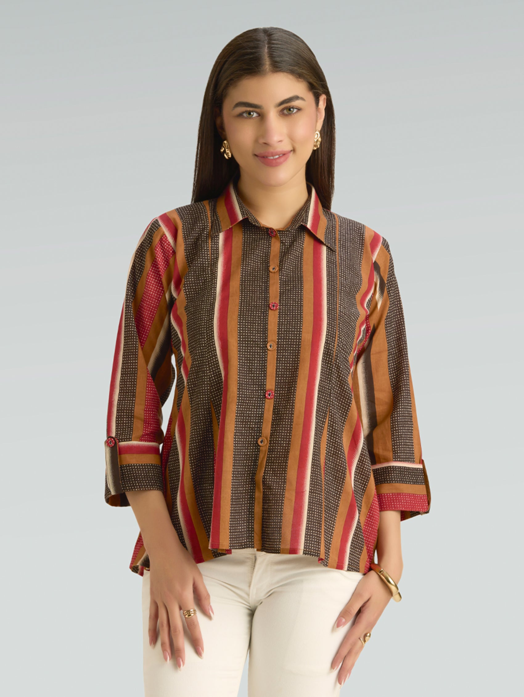 Woman wearing a patterned shirt with a plain background