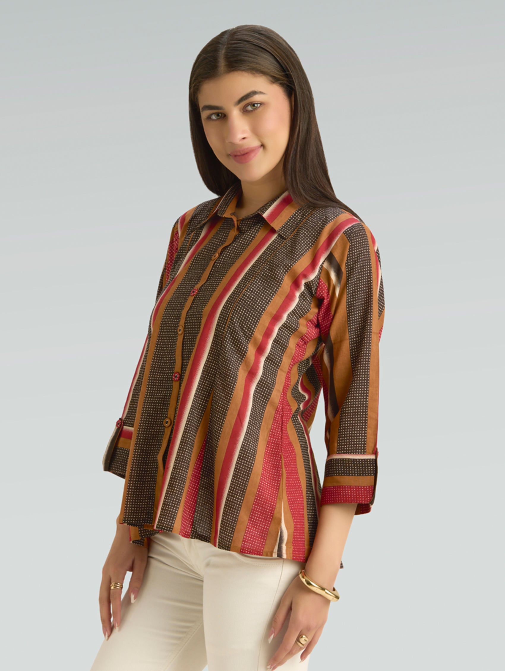 Woman wearing a patterned blouse with a plain background