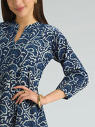 Woman wearing a blue patterned dress on a gray background