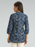 Woman wearing a blue patterned shirt on a gray background