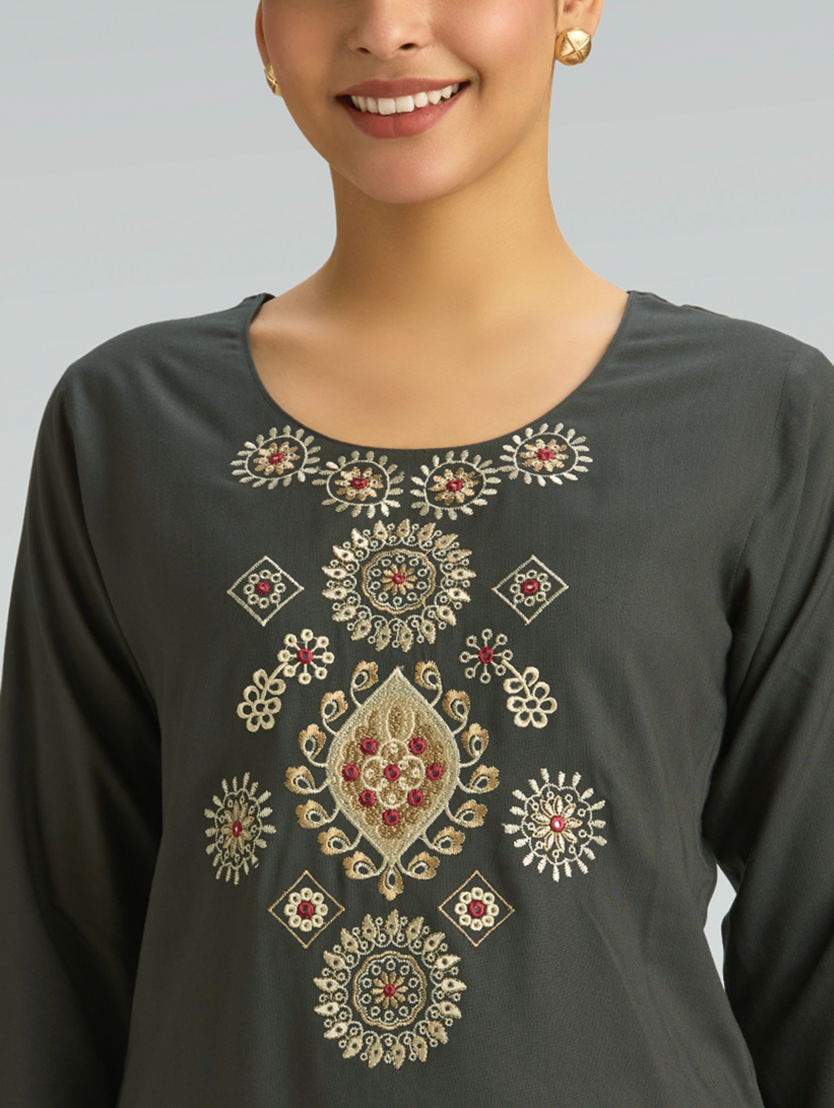 Dark gray long-sleeve top with intricate gold and red embroidery on a plain background