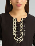 Black top with white embroidery on a neutral background