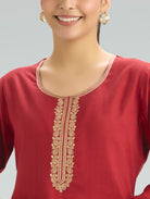 Red kurta with gold embroidery on a gray background