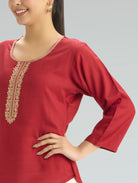 Red kurta with gold embroidery on a gray background