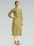 Woman wearing a green and beige striped kurta with white pants on a light gray background