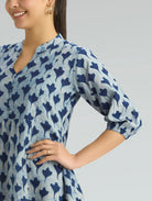 Woman wearing a blue patterned dress on a gray background