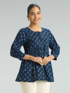 Woman wearing a blue floral patterned top on a gray background