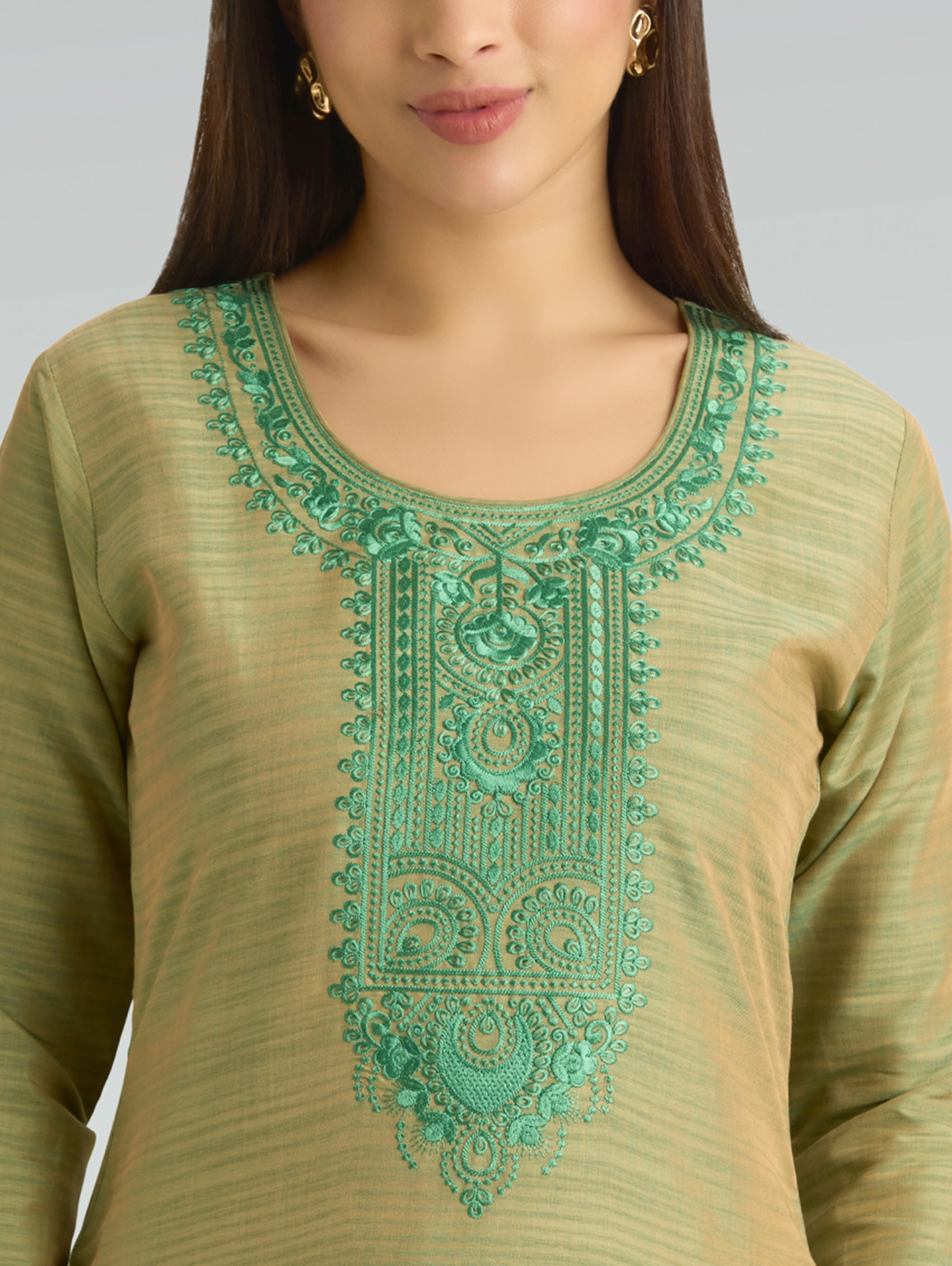 Green embroidered top worn by a model on a gray background