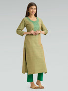 Woman wearing a green and beige traditional outfit on a gray background