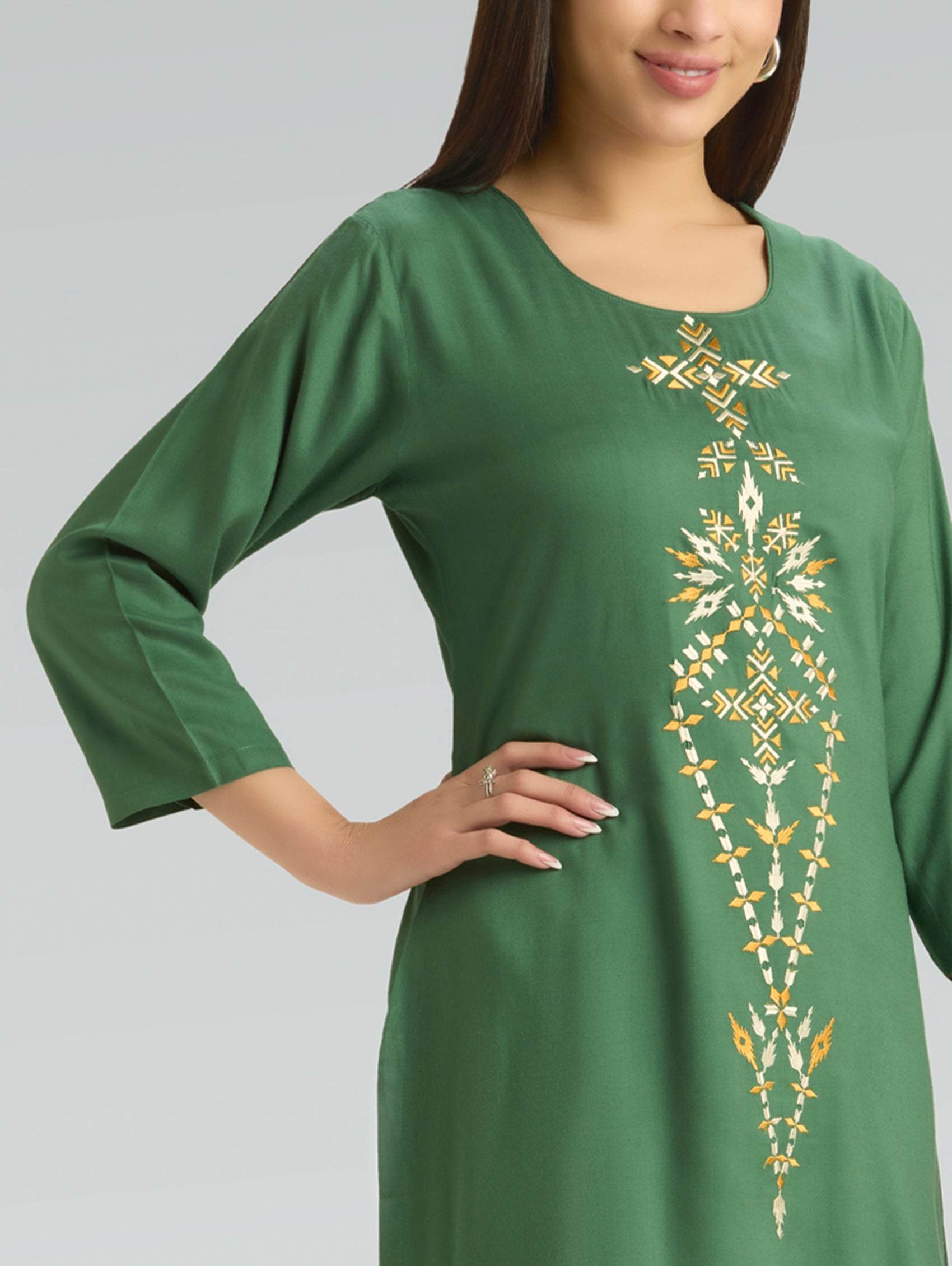 Green dress with gold embroidery on a gray background