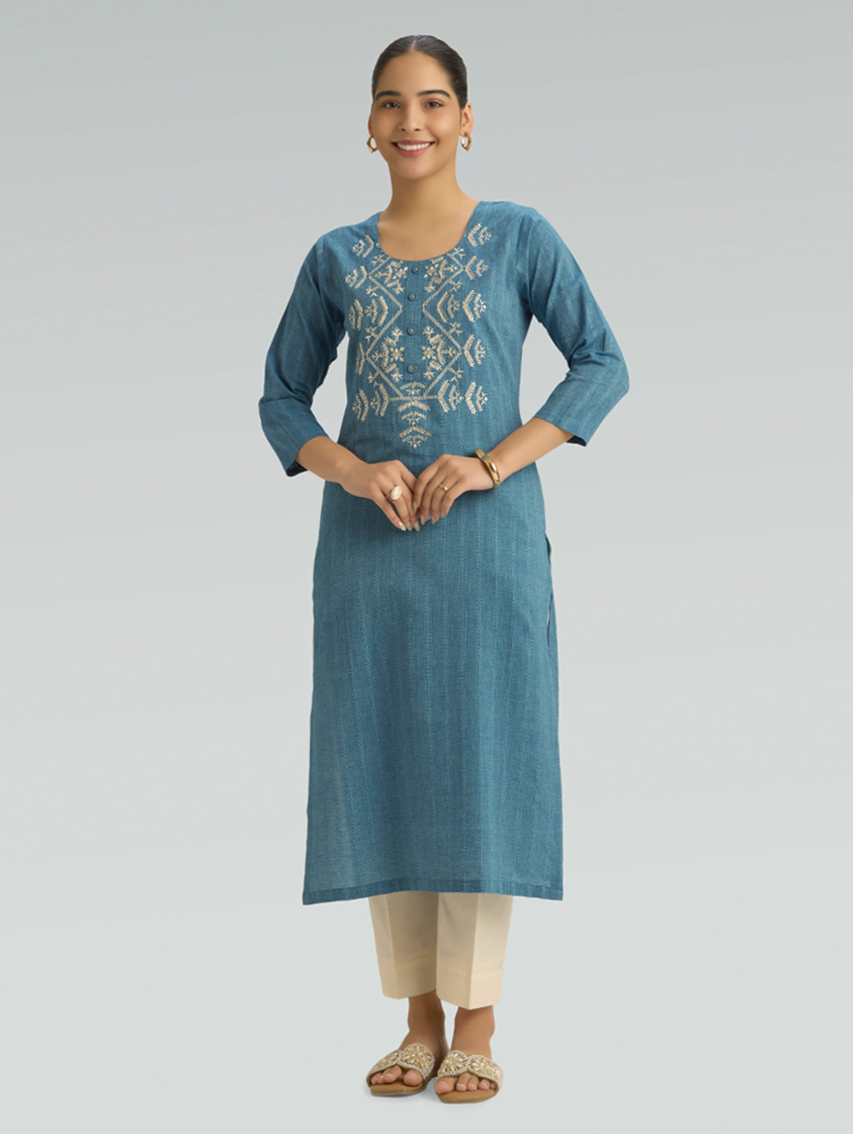 Woman wearing a blue kurta with a white pattern on a gray background