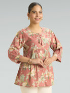 Woman wearing a floral blouse with a plain background