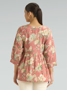 Woman wearing a floral blouse with a plain background