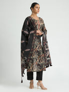 Woman wearing a floral patterned outfit with a black shawl on a white background