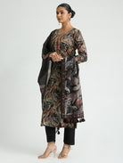 Woman wearing a patterned kurta with a black dupatta on a white background