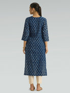 Woman wearing a blue floral dress on a gray background