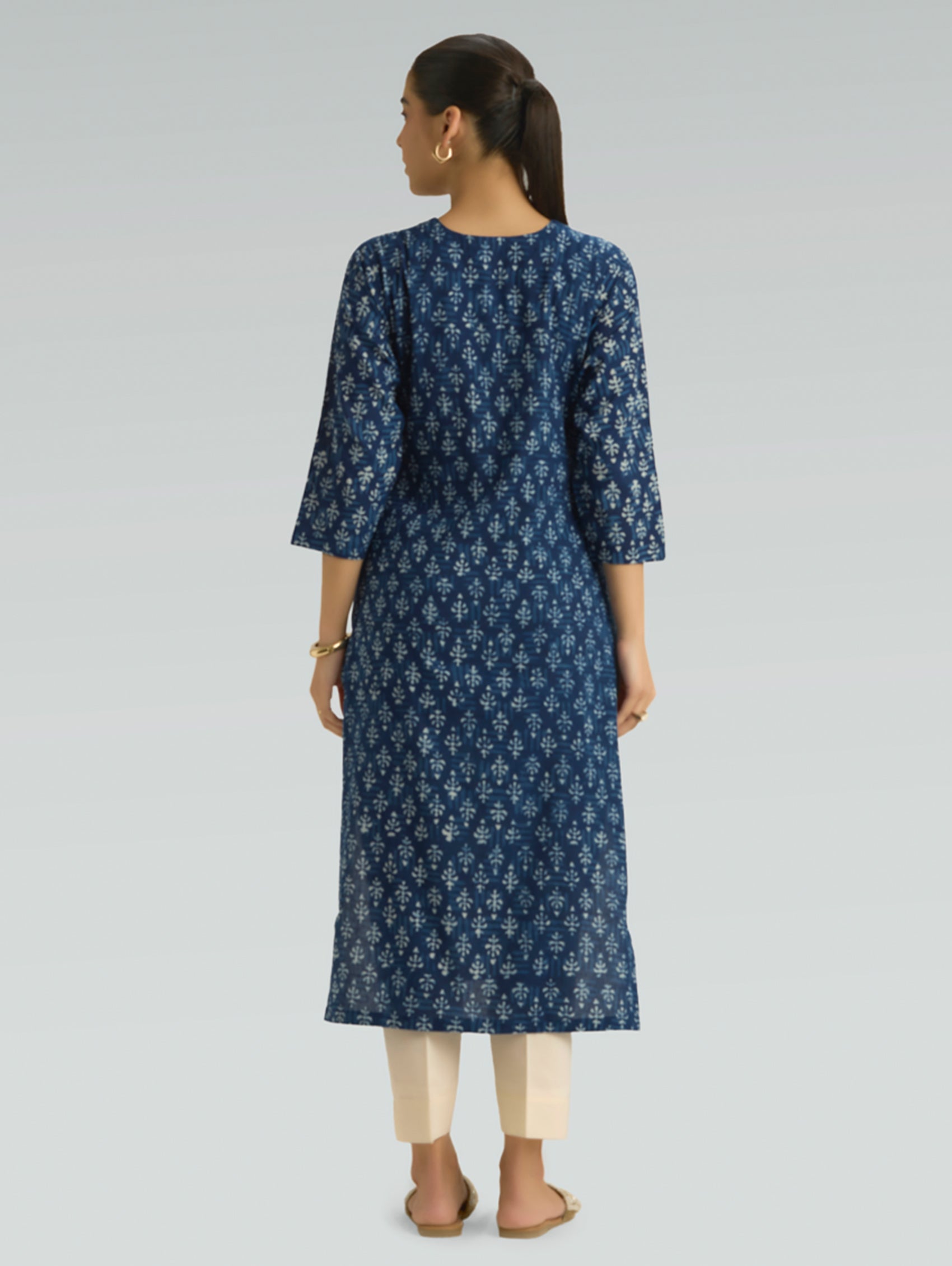 Woman wearing a blue floral dress on a gray background