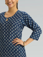 Woman wearing a blue patterned dress against a gray background