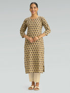 Woman wearing a patterned kurta with beige pants on a gray background