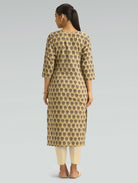 Woman wearing a patterned kurta with beige pants on a gray background