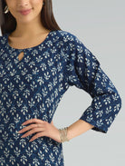 Woman wearing a blue and white patterned dress against a gray background