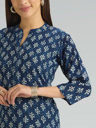 Woman wearing a blue patterned dress with a plain background