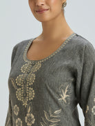 Gray embroidered top worn by a model on a light gray background