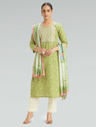 Woman wearing a green traditional outfit with a scarf on a gray background