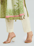 Green and white traditional outfit with tassels on a light gray background